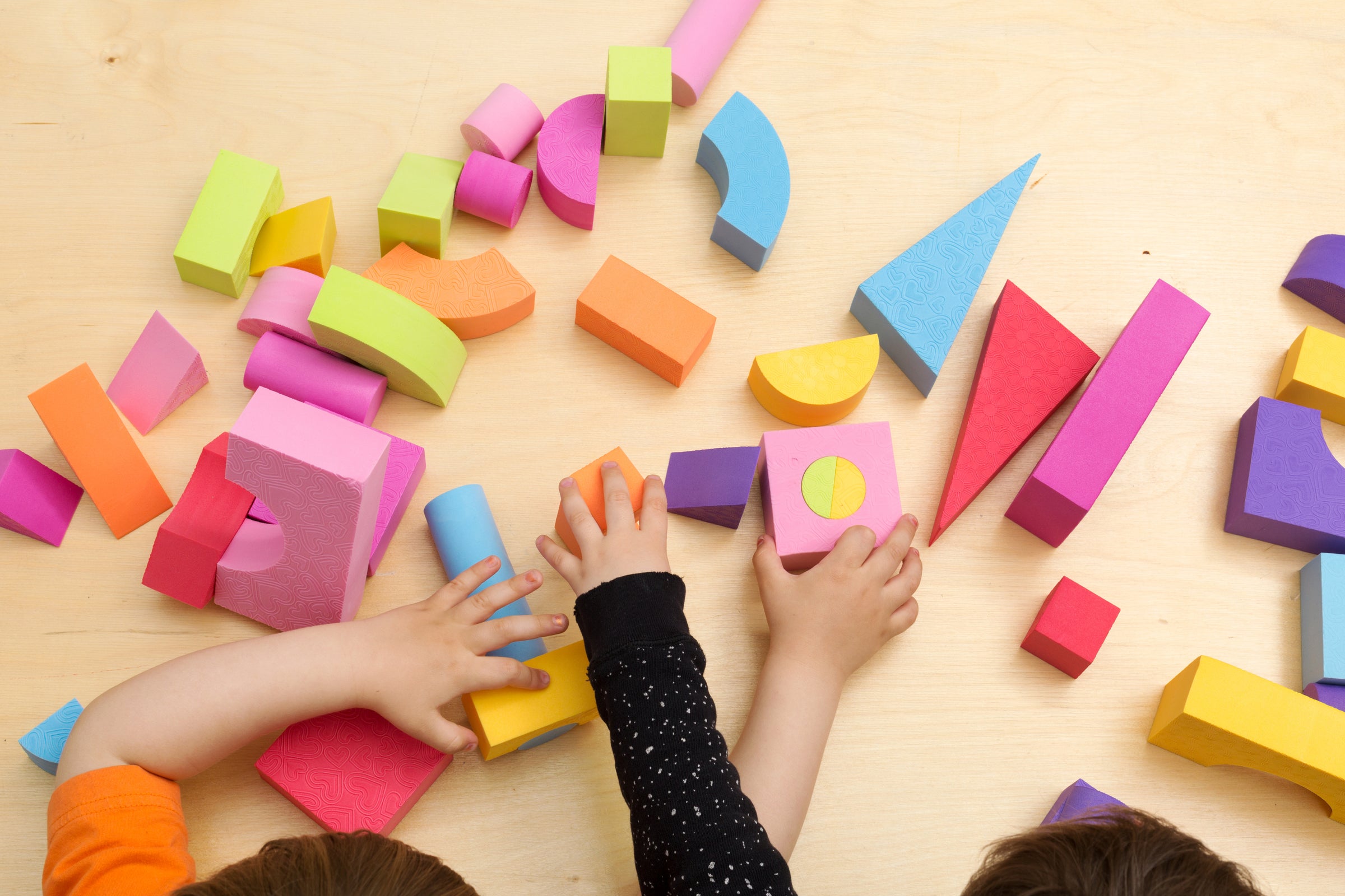 Kinder spielen mit Holzklötzen