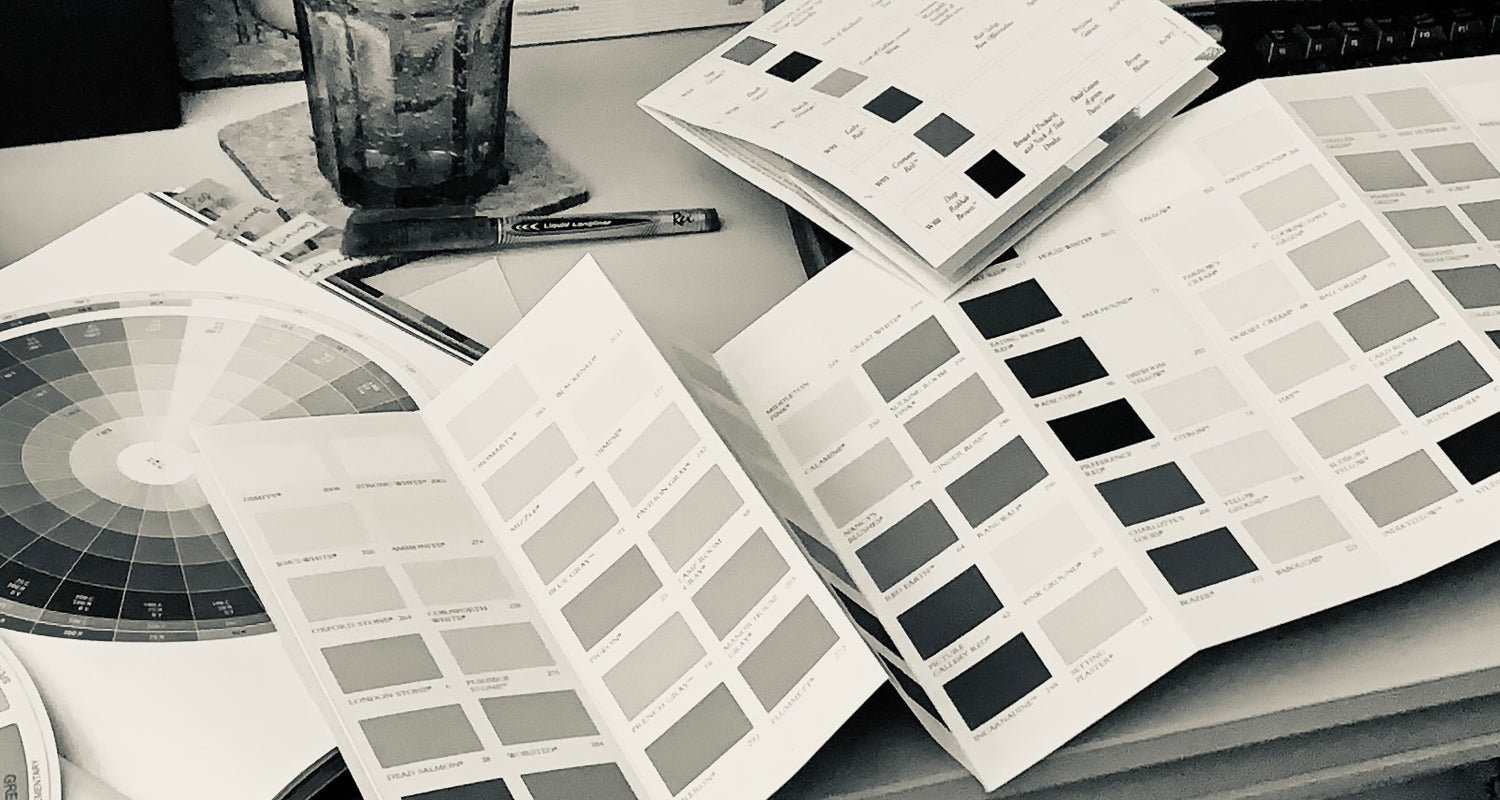 Schwarz-Weiß-Bild diverser Farbkarten und Muster zur Bearbeitung des Auftrages